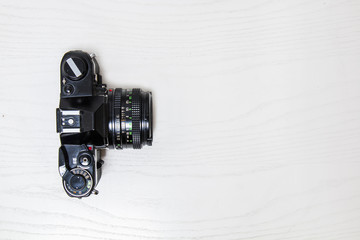 Old 35mm analog camera on white desk, isolated 