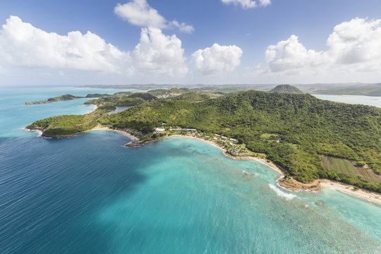Aerial view of the rugged coast of Antigua full of bays and beaches fringed by dense tropical vegetation, Antigua, Leeward Islands