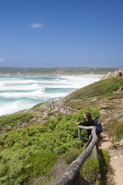 Woman at a path along the west coast at the beach of Rena Maiore, Sardinia