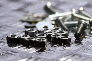 Nuts bolts washers.
Various nuts bolts and washers on a steel background.