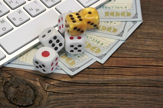 Computer Keyboard, Gaming Dices And Dollar Cash On Wood Backgrou