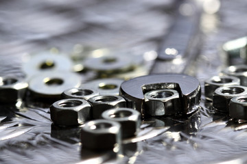 Nuts bolts washers spanner.
Various nuts bolts washers and a spanner on a steel background.