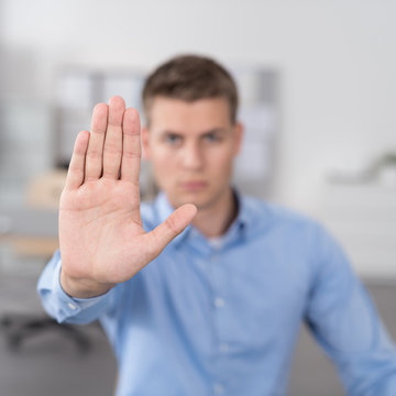 mann im b&uuml;ro streckt die hand nach vorne