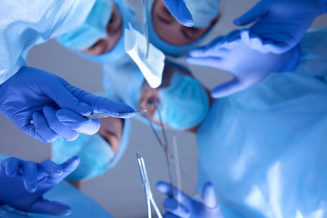 Surgeons holding medical instruments in hands and looking at