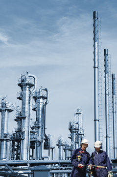two oil workers with large oil and gas refinery industry