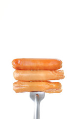 Sausage, prick with a fork  on a white background