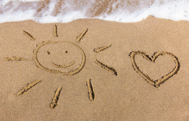 Sun and heart drawn on the sand