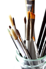 Paint brushes jar.
Various paint brushes in a glass jar isolated.