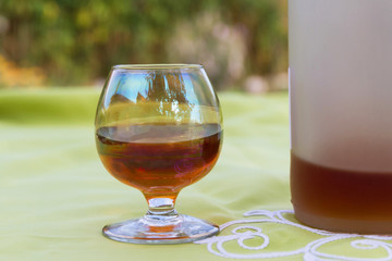 Copa y botella de cristal con licor alcoholico tostado
