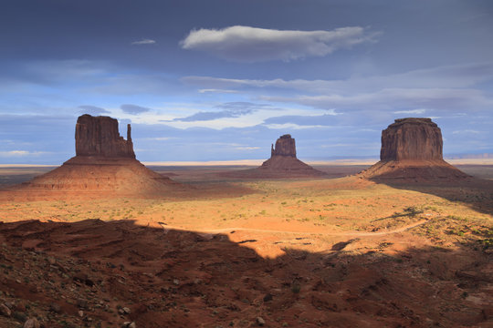 Mittens at dusk, late evening sun lights the desert floor, Monument Valley Navajo Tribal Park, Utah Arizona border