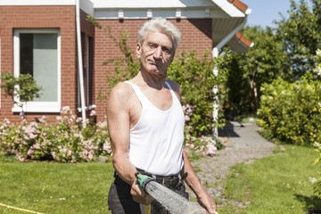 Mann gießt seinen Garten