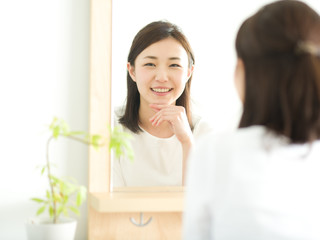 Obraz na płótnie Canvas スキンケア・鏡を見る若い女性