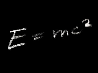 E equals mc squared drawn with white chalk isolated on black background