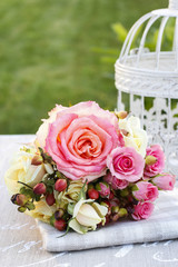 Bouquet of pink roses and vintage white bird cage