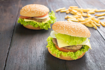 Delicious homemade hamburger with french fries on wooden desk.