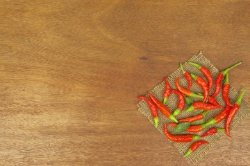 Freshly picked chili peppers on a wooden table. Preparation for the domestic processing of a crop. Decoration of chilli peppers. Place for text menu. Healthy fresh food.
