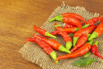 Freshly picked chili peppers on a wooden table. Preparation for the domestic processing of a crop. Decoration of chilli peppers. Place for text menu. Healthy fresh food.
