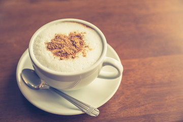 Hot latte art coffee on table ( Filtered image processed vintage