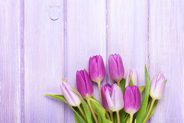 Purple tulips over wooden table