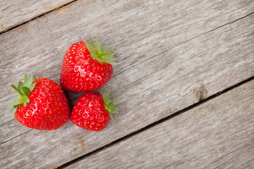 Ripe strawberries over wooden table background
