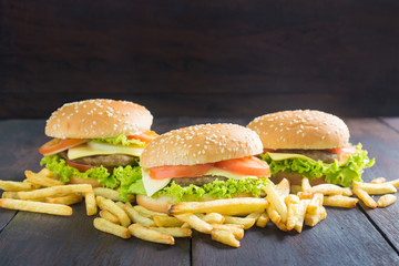 Delicious homemade hamburger with french fries on wooden desk.