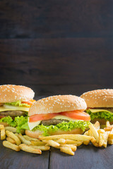 Delicious homemade hamburger with french fries on wooden desk.