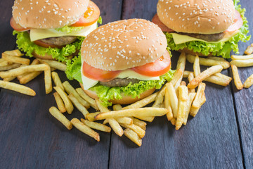 Delicious homemade hamburger with french fries on wooden desk.
