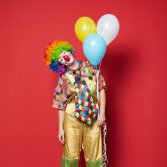 clown with balloons on red background