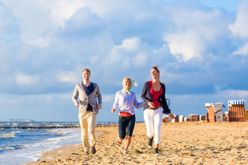 Freunde genießen Sonnenuntergang am Nordsee Strand 