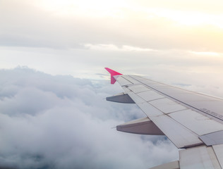 Fototapeta premium Wing of an airplane flying above the clouds