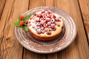 Homemade tasty cake with fresh wild raspberries and leaves decor