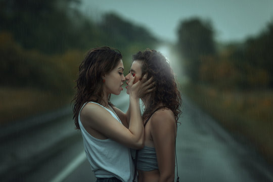 Girls kissing in the rain.