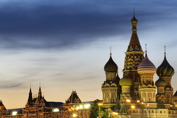 The onion domes of St. Basil's Cathedral and Gum department store in Red Square illuminated at night, Moscow, Russia