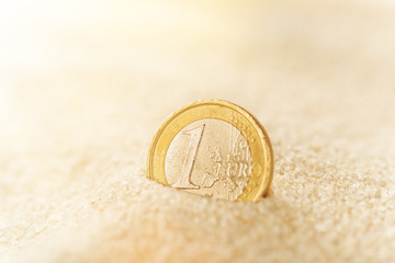 Euro coin in the sand