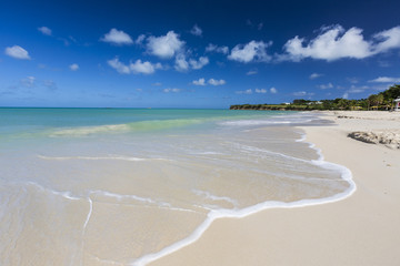 The waves of the Caribbean Sea crashing on the white sandy beach of Runaway Bay, north of the capital St. John's, Antigua, Leeward Islands