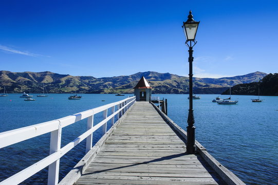 Fototapeta Long wooden pier in Akaroa, Banks Peninsula, Canterbury, South Island, New Zealand
