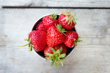 Top view ripe strawberries in an iron bowl