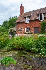 Fototapeta na wymiar malerisches Cottage mit historischer Packpferdbrücke in Allerford, Somerset, England