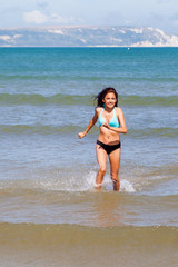 hübsches junges Mädchen läuft am Meer durchs Wasser