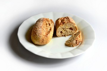 two pieces of multigrain bread roll on white plate