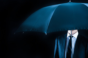 黒い背景で傘をさしている男性