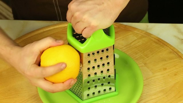 Men's hands make orange zest