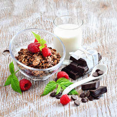 Chocolate granola, milk, and raspberries, muesli for healthy breakfast, selective focus
