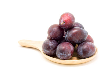 Fresh plums in wooden plate