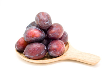 Fresh plums in wooden plate