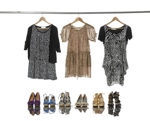 Set of female fashion clothing on hangers and shoes
