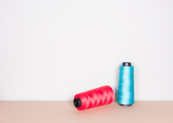 red and blue sewing threads on clear background