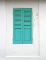 Fototapeta na wymiar Green wood window on a white wall