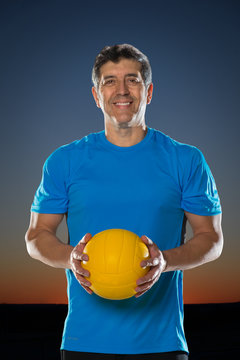 Mature Hispanic Man Holding Volleyball