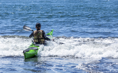 Fototapeta na wymiar Kayakers on sand coast of Pacific ocean
